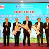 Le Quoc Minh, subjefe de la Comisión de Propaganda y Movilización de Masas del Comité Central del PCV, presidente-editor del periódico Nhan Dan y presidente de la Asociación de Periodistas del país, y el presidente de la Asociación Empresarial de Ho Chi Minh, Nguyen Ngoc Hoa, presentan flores para agradecer a los expertos que asisten al taller.