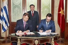 El presidente del Parlamento Vuong Dinh Hue en presencia de la firma de las actas del Comité conjunto de Cooperación Económica, Comercial y de Inversiones entre el ministro interino de Relaciones Exteriores de Uruguay, Nicolás Albertoni, (izquierda) y el viceministro de Industria y Comercio Do Thang Hai (Foto: VNA)