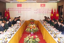El ministro de Defensa de Vietnam, general Phan Van Giang, dialoga con su homólogo chino, general Dong Jun. (Foto: VNA)
