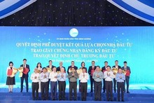 El primer ministro Pham Minh Chinh y los funcionarios del Estado y de la provincia de Binh Duong entregan licencias de registro de inversión a las empresas. (Foto: daibieunhandan.vn)