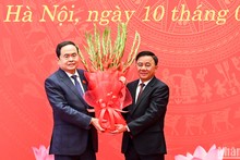 El miembro permanente del Secretariado del PCV, Tran Cam Tu, entrega flores para felicitar al secretario del Comité partidista de la ANV y presidente de este órgano, Tran Thanh Man.
