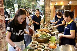Los visitantes degustan los platos en el festival. (Foto: VNA)