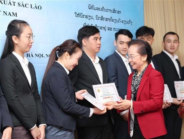 Nguyen Thi Doan, ex vicepresidenta de Estado y titular de la Asociación de Estímulo al Estudio de Vietnam, otorga becas a estudiantes de Laos. (Fotografía: VNA)