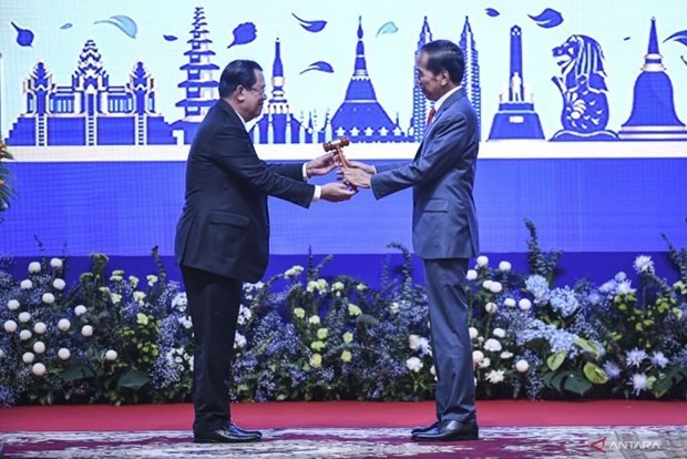 El presidente de Indonesia, Joko Widodo (derecha), recibe el relevo de la presidencia de la Asean del primer ministro de Camboya, Hun Sen (izquierda), en Phnom Penh, Camboya, el 13 de noviembre de 2022. (Fotografía: VNA)