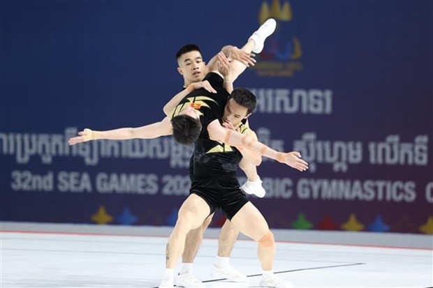 Los gimnastas vietnamitas Hoang Gia Bao, Le Hoang Phong y Nguyen Che Thanh compiten en la categoría de trío, logrando 19,267 puntos. (Fotografía: VNA)