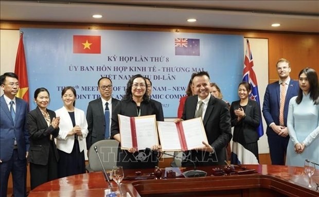 Las dos partes firman un documento que aprueba los compromisos bilaterales en la reunión. (Fotografía: VNA)