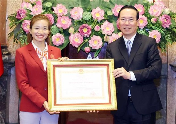 El presidente del país, Vo Van Thuong, entrega la Orden del Trabajo de segunda clase a la atleta Nguyen Thi Oanh- "chica de oro" del atletismo vietnamita. (Fotografía: VNA)