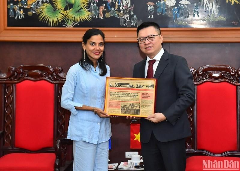 El presidente-editor del periódico Nhan Dan recibe un regalo de recuerdo entregado por Arlin Alberty Loforte, subdirectora del diario Granma. 