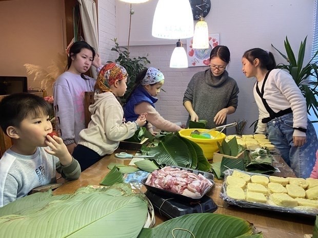 Los niños vietnamitas en Brusela aprende a hacer el banh chung (Fotografía: VNA)