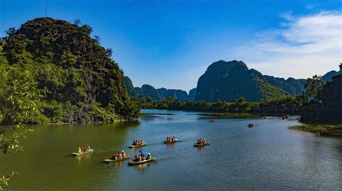Visitantes admiran el paisaje de Trang An y exploran misteriosas cuevas. (Fotografía: VNA)