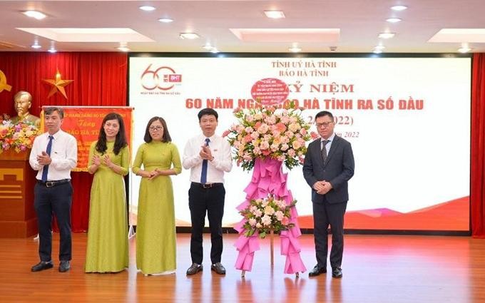 El redactor jefe de Nhan Dan, Le Quoc Minh (primero desde la derecha), entrega flores de felicitación al Consejo Editorial del periódico Ha Tinh. (Fotografía: Nhan Dan)