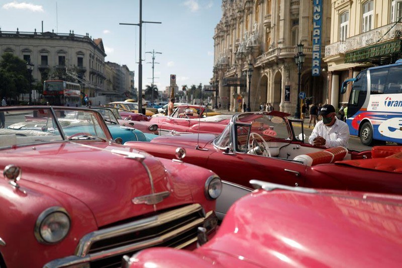 Un chófer esperando a turistas al lado de coches antiguos típicos de Cuba, en La Habana, el 16 de febrero de 2022. (Foto: Reuters)