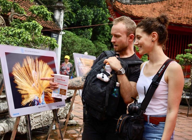 Turistas extranjeros visitan la exposición. (Fotografía: hanoimoi.com.vn)