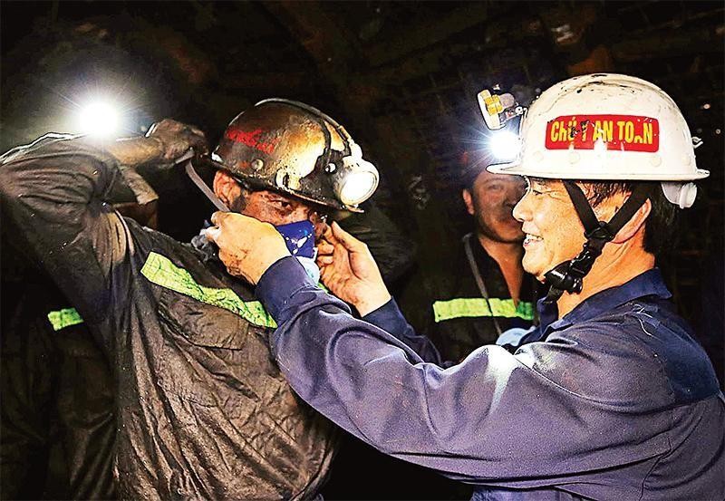 El presidente del Sindicato del Grupo de Industria de Carbón y Minerales de Vietnam, Le Thanh Xuan, entrega mascarillas contra el polvo a los empleados de la compañía de carbón Nam Mau. (Fotografía: Quoc Khuong)