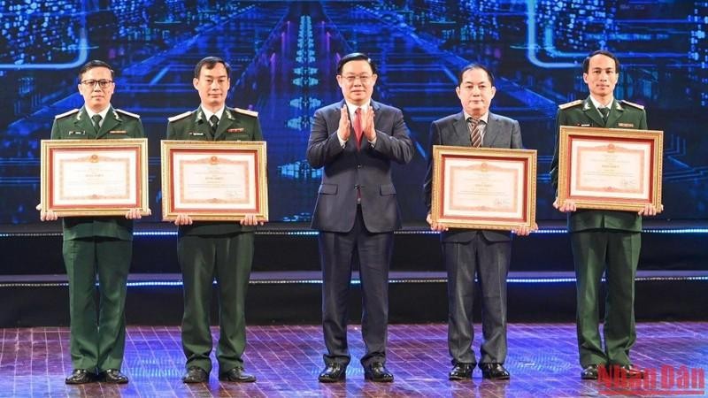 El presidente de la Asamblea Nacional de Vietnam, Vuong Dinh Hue, otorga el certificado de reconocimiento del Primer Ministro a los ganadores del primer premio. (Fotografía: Nhan Dan)