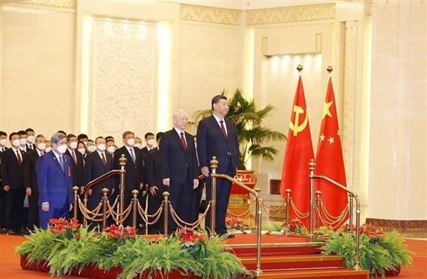 El secretario general del Partido Comunista de Vietnam, Nguyen Phu Trong, y el máximo dirigente partidista y presidente de China, Xi Jinping, escuchan los himnos nacionales de sus países. (Fotografía: VNA)