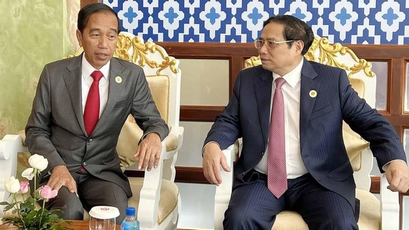 El primer ministro de Vietnam, Pham Minh Chinh (derecha), conversa con el presidente de Indonesia, Joko Widodo. (Fotografía: VNA)