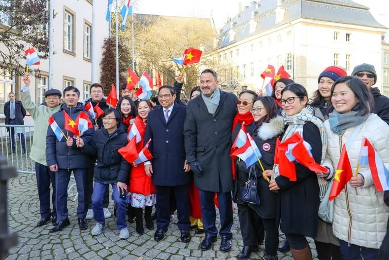 El primer ministro de Vietnam, Pham Minh Chinh, y su homólogo de Luxemburgo, Xavier Bettel, posan junto con vietnamitas residentes en el país europeo. (Fotografía: VGP)