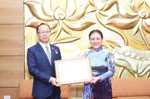 La presidenta de la UOAV, Nguyen Phuong Nga, entrega la insignia “Por la paz y la amistad entre las naciones”, al embajador saliente de Camboya, Chay Navuth. (Fotografía: VNA)