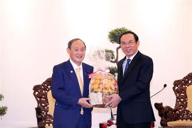 El miembro del Buró Político y secretario del Comité partidista en Ciudad Ho Chi Minh, Nguyen Van Nen, y el ex primer ministro de Japón, Suga Yoshihide. (Fotografía: VNA)