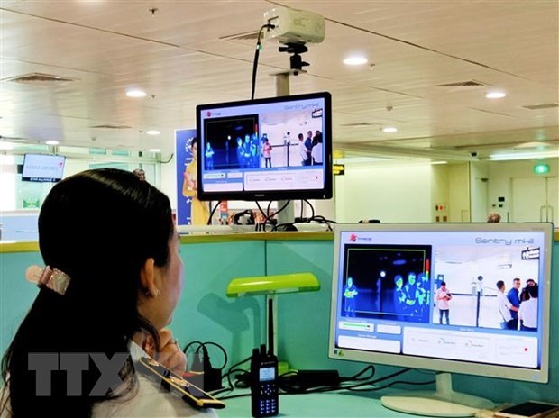 El personal del aeropuerto de Tan Son Nhat revisa la pantalla del termómetro remoto para los pasajeros internacionales que llegan a Vietnam. (Fotografía: VNA)