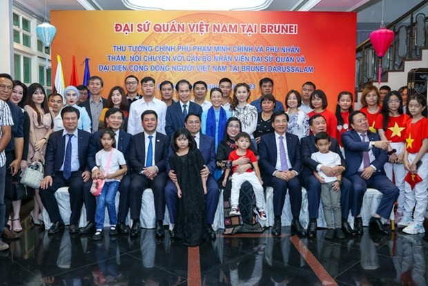 El primer ministro de Vietnam, Pham Minh Chinh, y representantes de la comunidad de compatriotas residentes en Brunéi. (Fotografía: VNA)