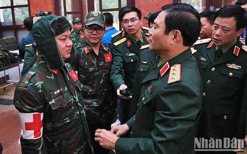 El teniente general Nguyen Tan Cuong (derecha) charla con los oficiales sobre la tarea encomendada. (Fotografía: Nhan Dan)