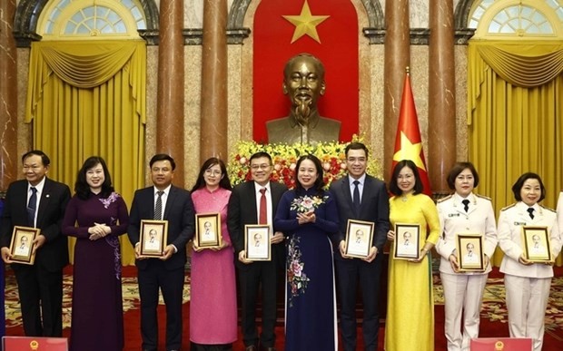 La presidenta interina de Vietnam, Vo Thi Anh Xuan, y los médicos y trabajadores de la salud en la reunión. (Fotografía: VNA)