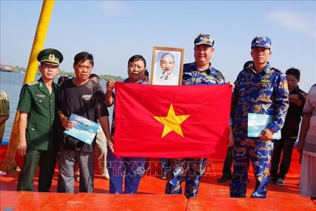 La guardacostas de Ba Ria-Vung Tau regala la bandera nacional a pescadores locales. (Fotografía: VNA)