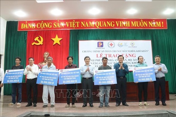 El expresidente del país Truong Tan Sang (tercero desde la derecha) entrega apoyo financiero a pescadores desfavorecidos en Ben Tre. (Fotografía: VNA)