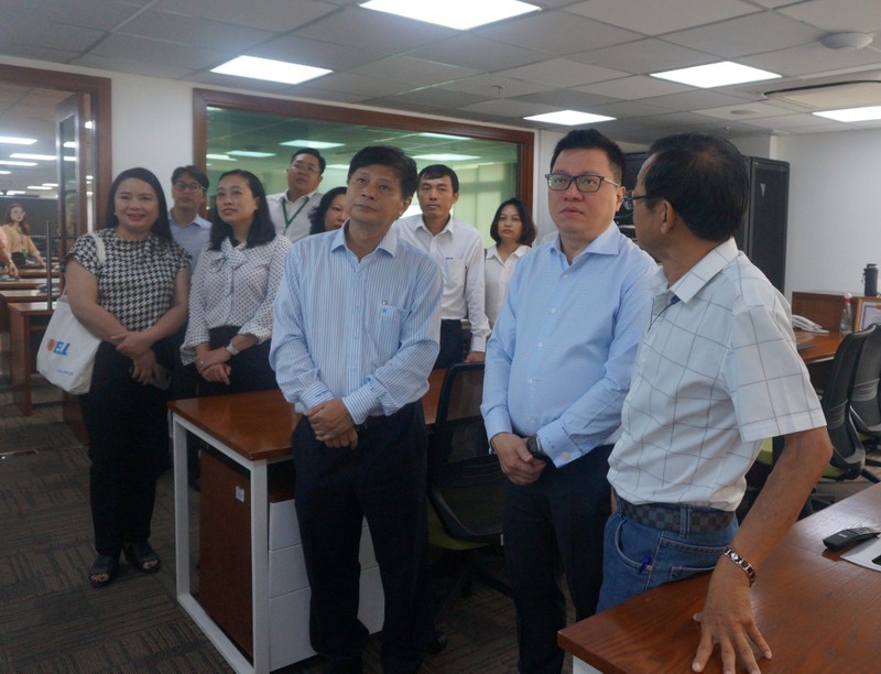 Ejecutivos del centro enseñan a Quoc Minh las instalaciones al servicio de la cobertura periodística. (Fotografía: Nhan Dan)