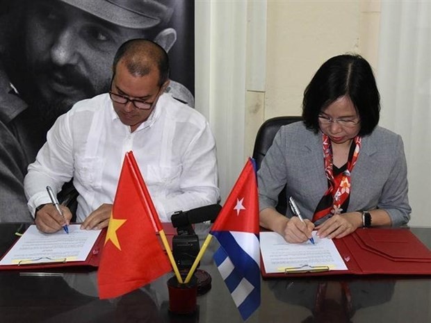 El presidente de PL, Luis Enrique González Acosta, y la directora general de la VNA, Vu Viet Trang, firman un nuevo acuerdo de cooperación. (Fotografía: VNA)