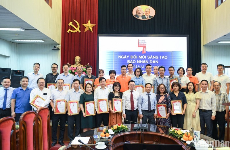 Miembros del Consejo Editorial de Nhan Dan posan junto a los autores y colectivos de autores honrados en el evento. (Fotografía: Nhan Dan)