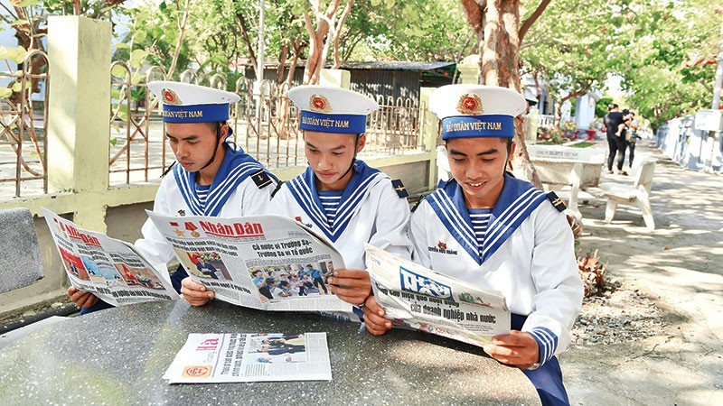 Oficiales acantonados en la isla de Truong Sa (Spratly), del homónimo archipiélago vietnamita, leen el periódico Nhan Dan. (Fotografía: Dang Khoa)