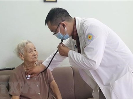 Especialista del Hospital del Distrito 11 de Ciudad Ho Chi Minh ofrece chequeo médico a una anciana. (Fotografía: VNA)