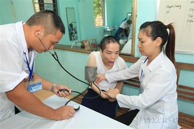 Los empleados médicos realizan la atención médica para la persona afectada por el Agente Naranja en el Centro de Atención, Nutrición y Tratamiento de Víctimas de esa química tóxica en Hanói. (Fotografía: VNA)