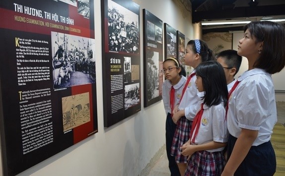 Jóvenes adquieren información sobre los exámenes realizados en el Templo de la Literatura, primera universidad de Vietnam. (Fotografía: VNA)