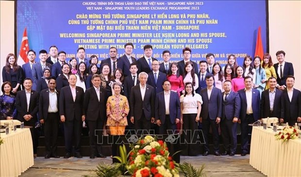 El primer ministro Pham Minh Chinh y su homólogo de Singapur, Lee Hsien Loong, con jóvenes de ambos países. (Fotografía: VNA)