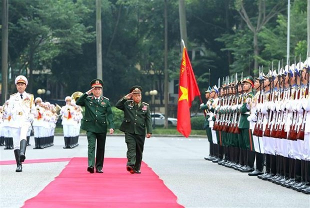 El jefe de la Dirección General de Política del Ejército Popular de Vietnam, Luong Cuong, y su homólogo laosiano, Thongloi Silivong, pasan revista a la guardia de honor. (Fotografía: VNA)