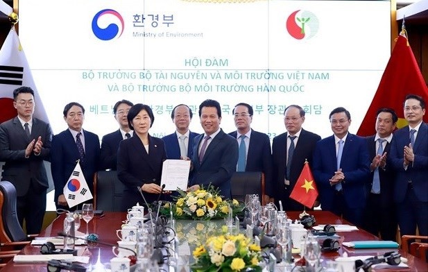 El ministro de Medio Ambiente y Recursos Naturales de Vietnam, Dang Quoc Khanh, y su homóloga sucoreana, Han Wha-jin, firman el memorando de cooperación. (Fotografía: VNA)
