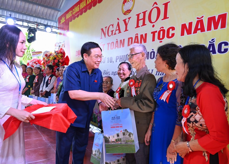 El presidente de la Asamblea Nacional de Vietnam, Vuong Dinh Hue, entrega regalos a familias con méritos revolucionarios y hogares con dificultad económica. (Fotografía: Nhan Dan)