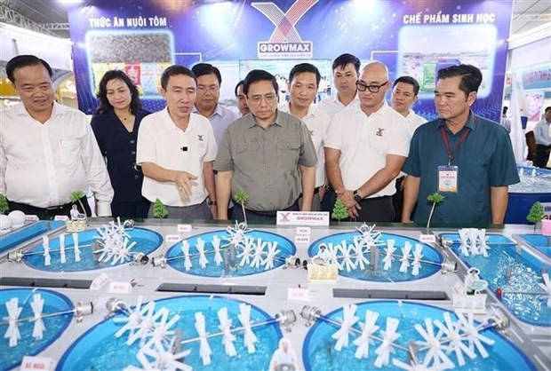 El primer ministro Pham Minh Chinh visita el stand de productos de cultivo y procesamiento de camarón en el Festival del Camarón de Ca Mau 2023. (Fotografía: VNA)