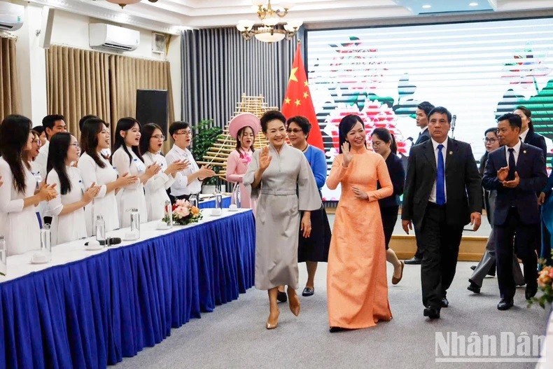 Phan Thi Thanh Tam, esposa del presidente vietnamita, Vo Van Thuong, y Peng Liyuan, cónyuge del secretario general del Partido Comunista y presidente de China, Xi Jinping, en el intercambio. (Fotografía: Nhan Dan)