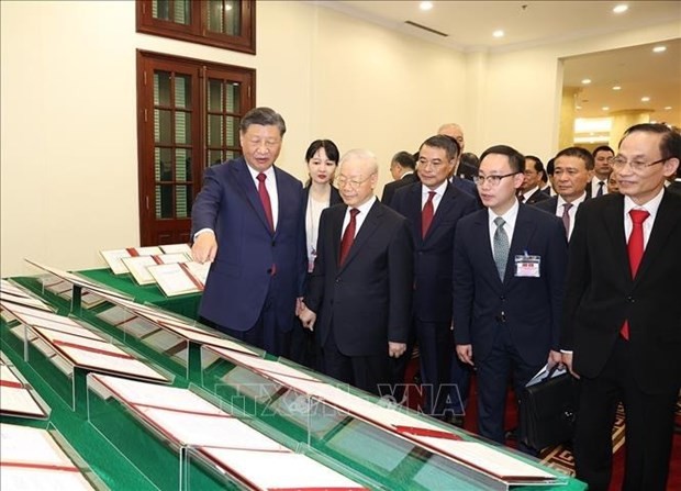 El secretario general del Partido Comunista de Vietnam, Nguyen Phu Trong, y su invitado chino miran los documentos firmados. (Fotografía: VNA)