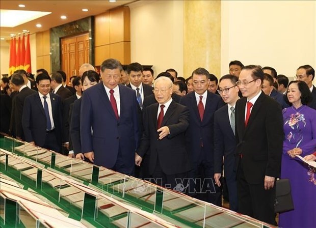 El secretario general del Partido Comunista de Vietnam, Nguyen Phu Trong, y su invitado chino miran los documentos firmados. (Fotografía: VNA)