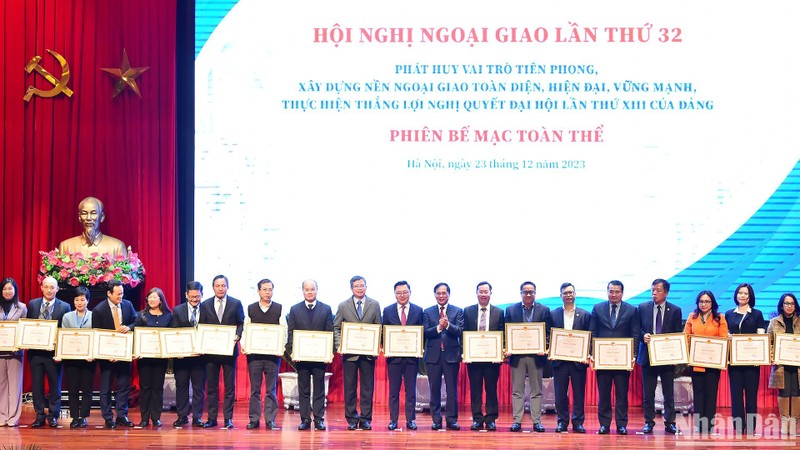 El canciller Bui Thanh Son entrega certificados de mérito a personas y colectivos por sus desempeño en tareas diplomáticas. (Fotografía: Nhan Dan)