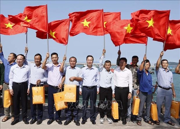El presidente Vo Van Thuong entrega la bandera nacional a los pescadores del distrito insular de Co To, provincia de Quang Ninh. (Fotografía: VNA)