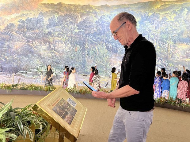 Un turista extranjero escanea el código QR para aprender sobre la pintura. (Fotografía: baodienbienphu.com.vn)