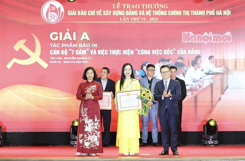 Los compañeros Le Quoc Minh y Nguyen Thi Tuyen entregan el premio A a una autora.