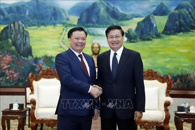 El secretario general del Partido Popular Revolucionario y presidente de Laos, Thongloun Sisoulith, recibe al secretario del Comité partidista en Hanói, Dinh Tien Dung. (Fotografía: VNA)